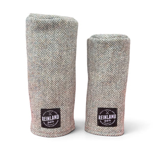 Two golf club headcover sleeves in a gray and beige herringbone tweed fabric, standing upright on a white background. Each sleeve features a black square patch at the bottom with the 'Reinland Golf Co' logo.