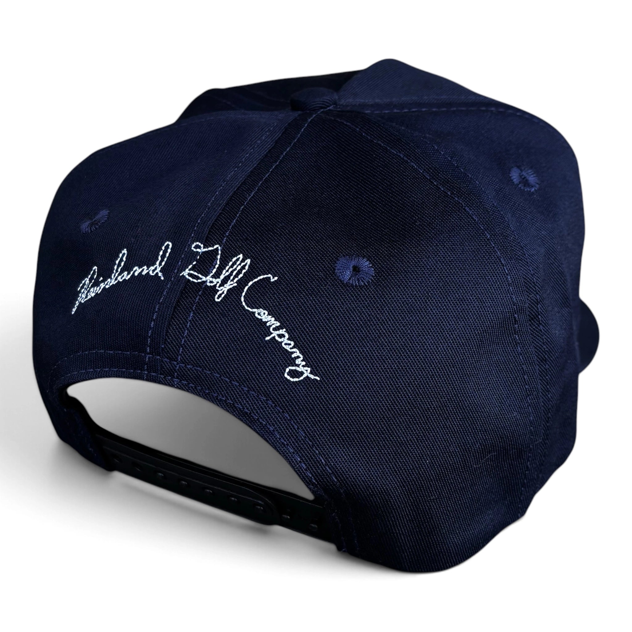A navy blue snapback cap shown from a three-quarters back view, featuring white embroidered script reading 'Reinland Golf Company' on the side panel.