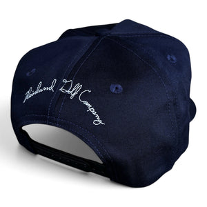 A navy blue snapback cap shown from a three-quarters back view, featuring white embroidered script reading 'Reinland Golf Company' on the side panel.